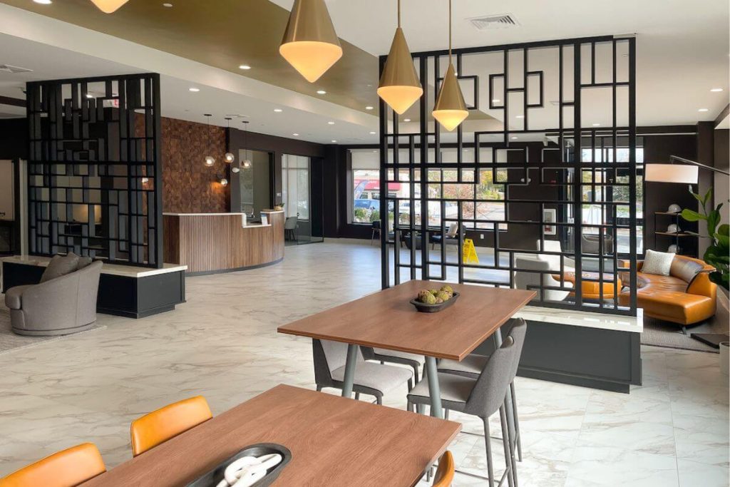 Weymouth Mixed Use Development lobby design with desk, seating and meeting areas featuring wood, tile and a modern design