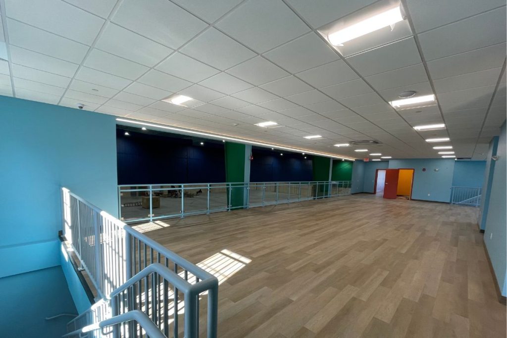 Viewing area at a Westborough Sports Facility for badminton with vibrant paint colors including blue, green and orange