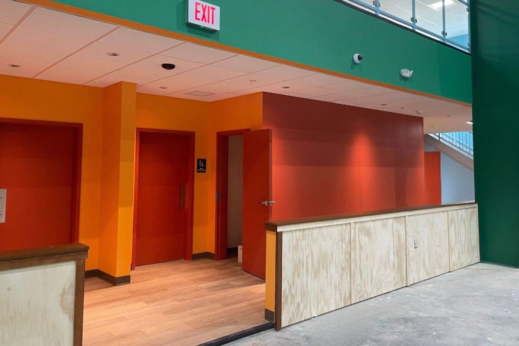 Exterior of restrooms in bright red and orange at the badminton facility in Westborough MA